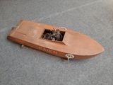 une maquette en bois d'un bateau posée par terre