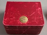 a small red box with a gold button on it