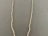 a white pearl necklace with a gold clasp