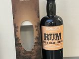 une bouteille de rhum posée à côté d'une boîte sur une table