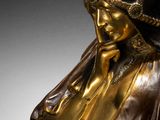 bronze statue of a woman with a hat on her head