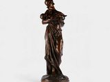 une statue en bronze représentant une femme tenant un bébé dans ses bras