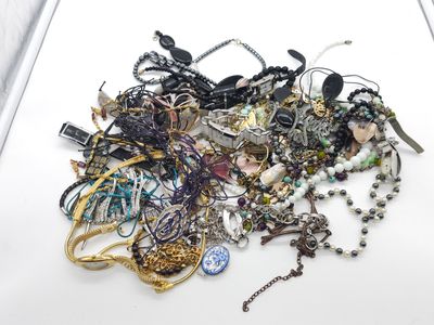 une pile de bijoux assortis sur une surface blanche