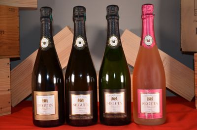 four bottles of wine are lined up on a red table