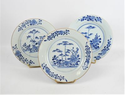 trois assiettes bleues et blanches ornées de fleurs et d'arbres