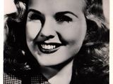 an old black and white photo of a woman with a smile on her face