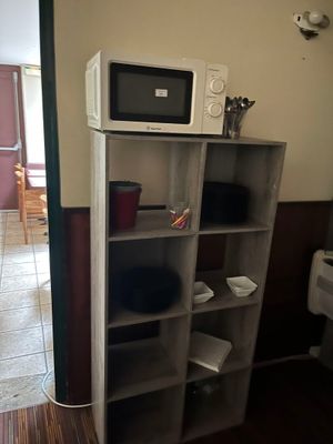 un micro-ondes posé sur une bibliothèque dans une cuisine