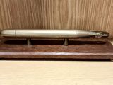 un stylo en argent posé sur un support en bois, sur une table