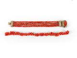 a close up of a red beaded bracelet on a white background