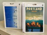 two posters of portland and oregon on the table