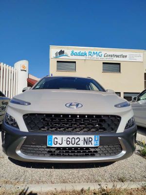 the front of a silver car parked in front of a building
