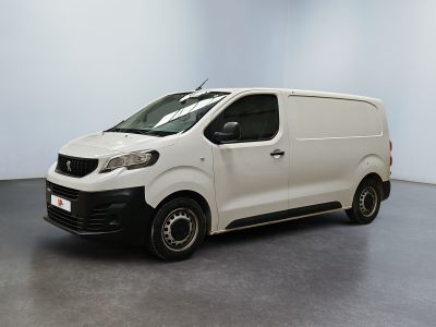 La petite camionnette blanche est garée dans une grande pièce.