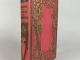 un livre rose aux bords dorés, avec un motif floral sur la couverture
