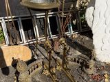 une petite table sur laquelle se trouve un bain d'oiseaux, devant un mur de pierre