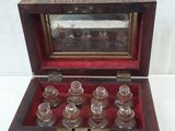 a small wooden box with six glass bottles inside of it