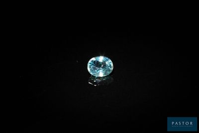 a close up of a blue diamond on a black surface