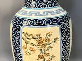 a vase with a floral design on it sitting on a table