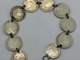 un gros plan d'un bracelet orné de pièces de monnaie