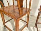 a wooden chair that is sitting on a tile floor