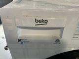 a white washing machine sitting on top of a counter