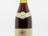 une bouteille de vin rouge avec une étiquette blanche posée sur une surface blanche
