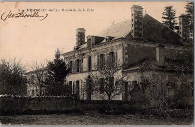 une vieille photo d'une grande maison avec une tour horloge