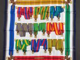 a square scarf with colorful ribbons hanging from it ' s sides