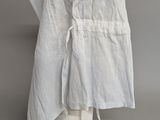 white apron on a mannequin head on a grey background