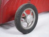a red toy car that is sitting on a white surface