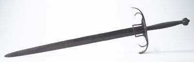 a black sword that is laying on a white surface