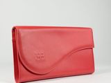 a red leather clutch bag with a logo on the front