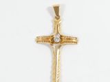 a close up of a cross on a white surface with a diamond