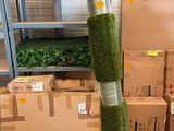 de nombreuses caisses remplies d'herbe verte posées par terre à côté d'un poteau
