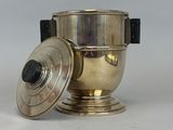 a silver cup with a lid sitting on a white surface