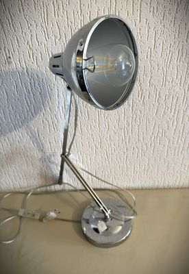 une lampe posée sur une table à côté d'un mur