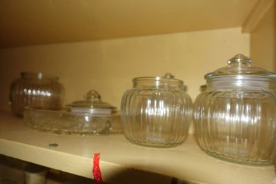 de nombreux bocaux en verre sur une étagère de la cuisine