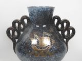 un vase bleu avec une anse dorée sur fond blanc