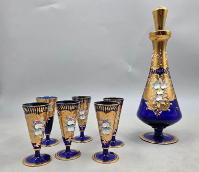 cinq verres et une carafe posés sur une table