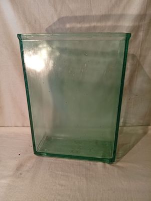 un vase en verre vert muni d'un couvercle, posé sur une table