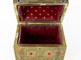 a gold and red box that is sitting on a white surface