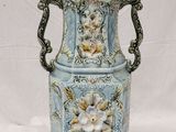 a blue vase with flowers on it sitting on a white surface