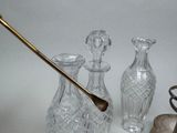 three glass vases and a spoon sitting on a table