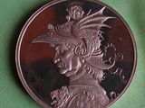 a silver coin with a picture of a woman wearing a hat