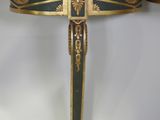 an image of a cross made of wood and metal with a green and gold decoration