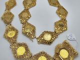 a gold plated necklace and bracelet set on a white surface