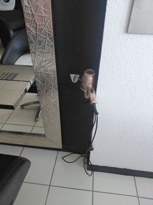 a hair dryer sitting on the floor next to a mirror