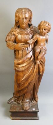 statue en bois représentant une femme tenant un enfant dans ses bras, posée sur un socle