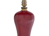 un vase rouge avec un couvercle doré sur fond blanc