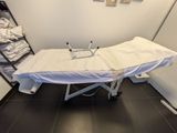 a white table with a white sheet on it in a room