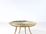 une table avec un plateau en marbre et des pieds en bois, posée sur un plan de travail blanc